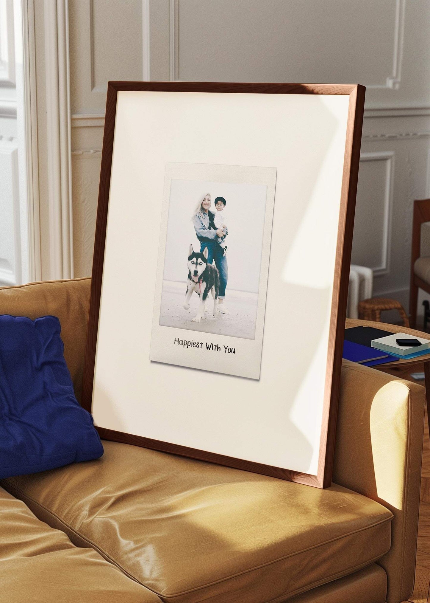 Personalized photo gift of a woman with her child and dog in a large walnut frame in the style of a nostalgic instant film custom polaroid photo with frame leaning on a sofa. The custom caption reads "Happiest with you".