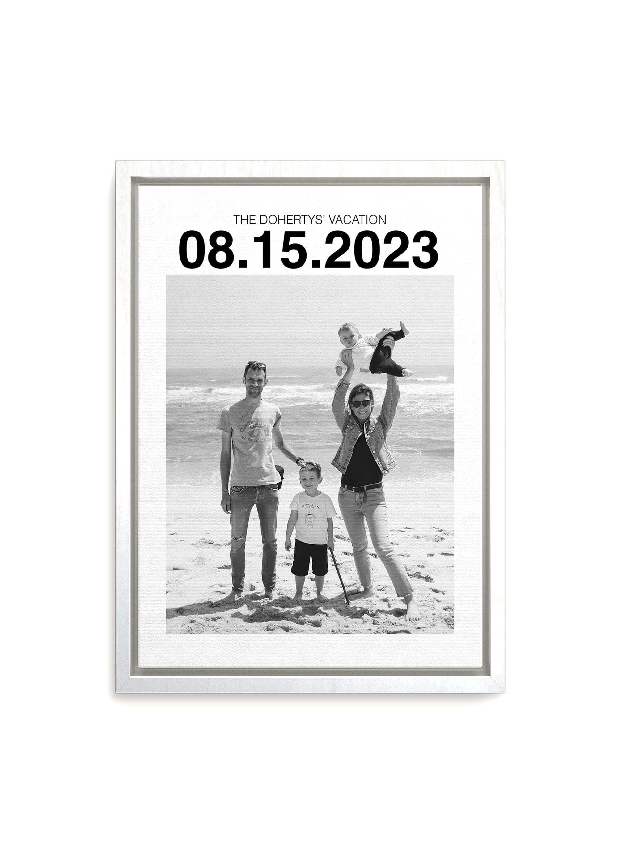 custom personalized black and white photo of a family on holiday. The white framed canvas has a large custom date at the top and the canvas sits on a white background.