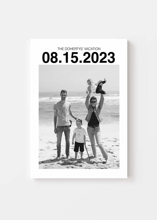 custom personalized black and white photo of a family on holiday. The canvas has a large custom date at the top and the canvas sits on a white background.