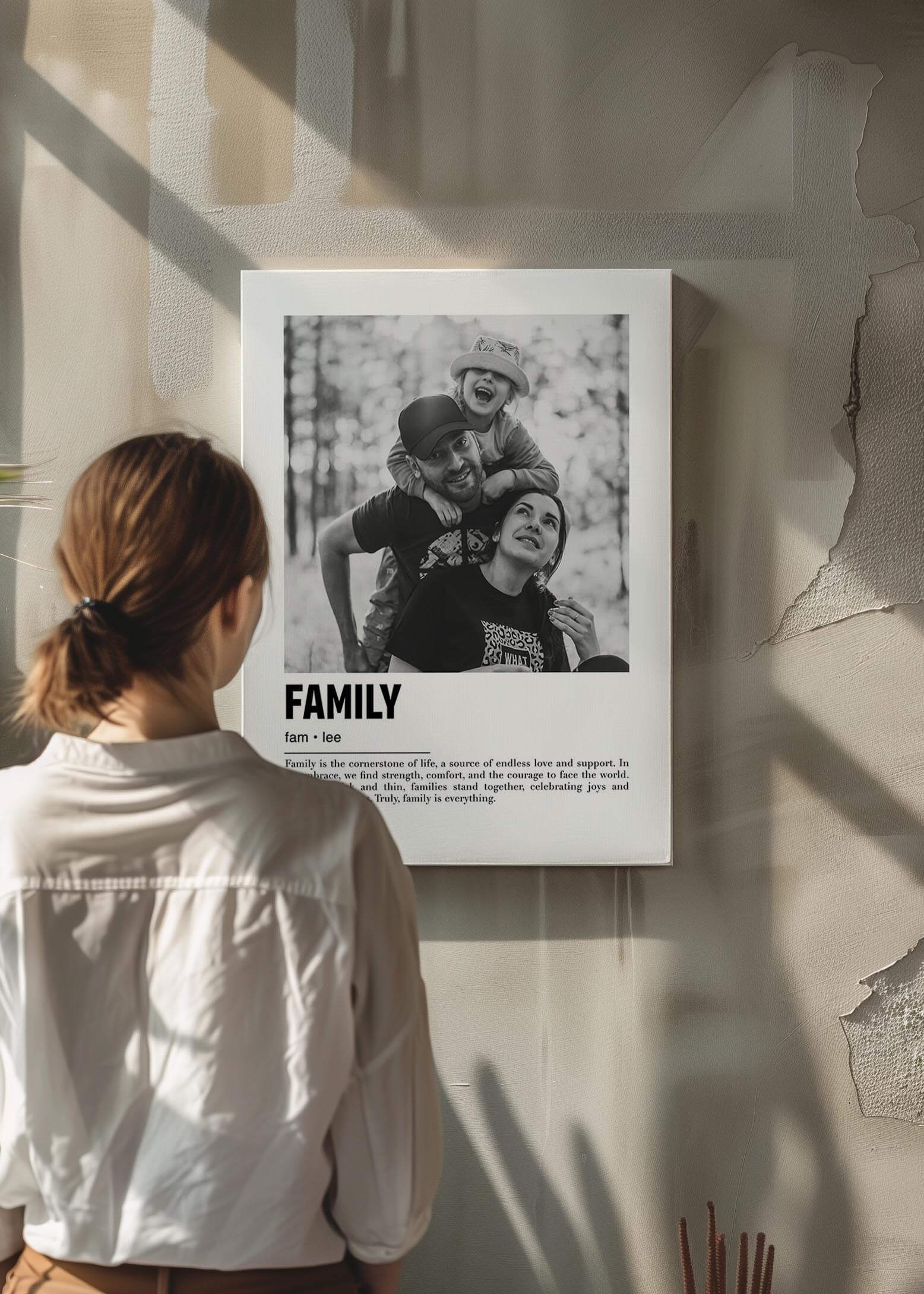 Woman looking at a personalized black and white photo gift on canvas with custom caption on modern raw concrete wall.