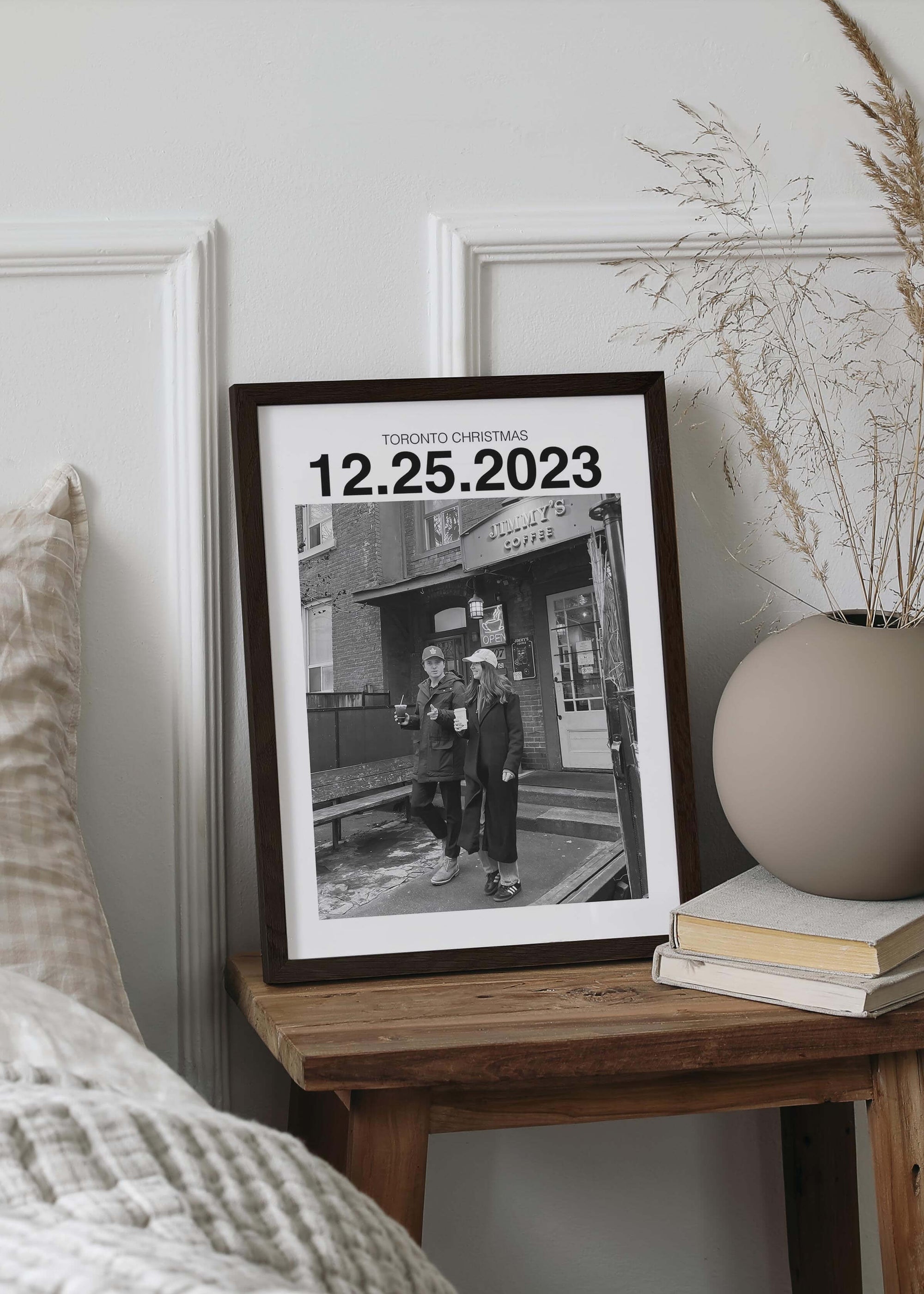 Personalized black and white photo gift with custom date in black frame on bedside table.